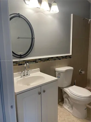 a bathroom with a toilet a sink and mirror