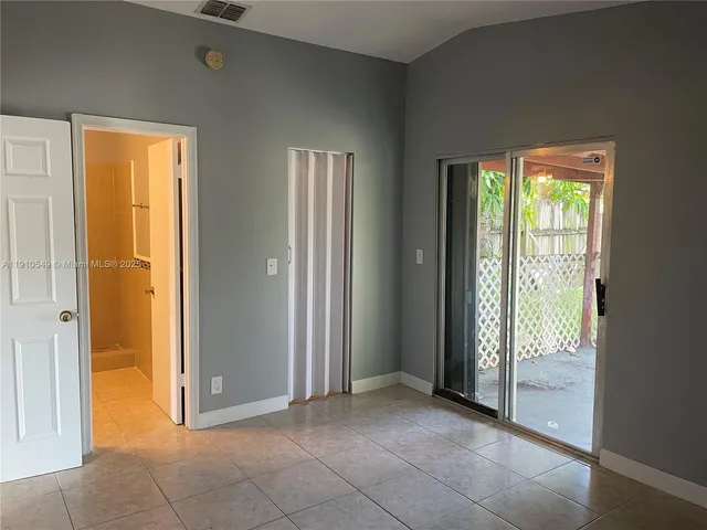 an empty room that has a window and front door