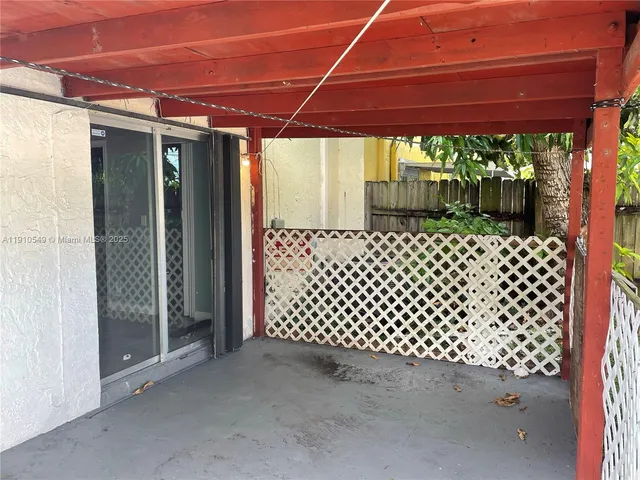 a backyard of a house with a large window and wooden fence