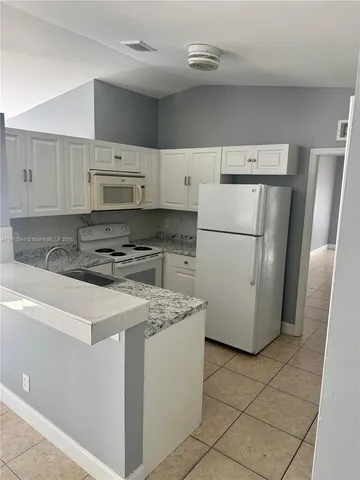 a kitchen with a refrigerator sink stove and cabinets