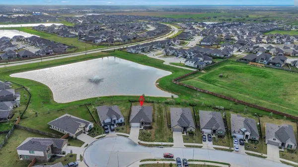 an aerial view of a house with a garden and lake view