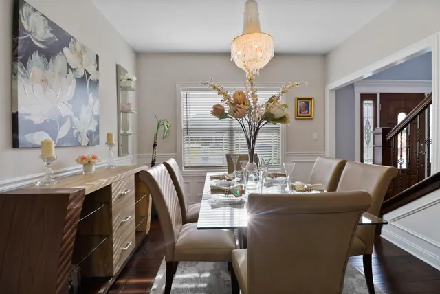 a dining room with furniture a chandelier and wooden floor