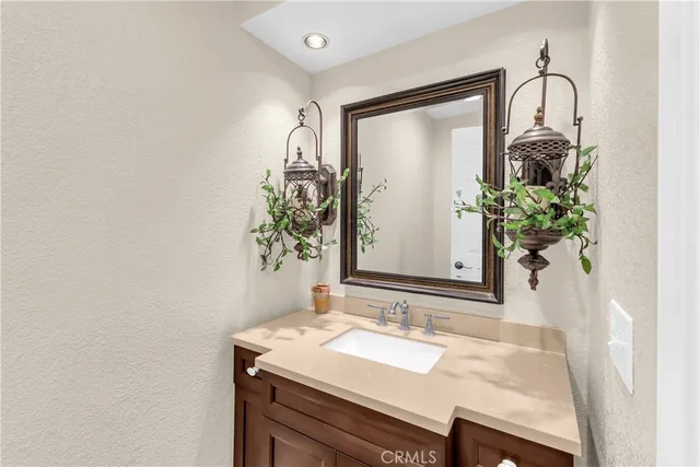 a bathroom with a granite countertop sink a mirror and a shower