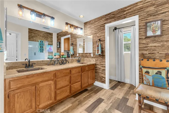a spacious bathroom with a double vanity sink a mirror and a shower