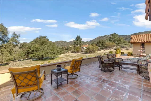 a view of a terrace with furniture and a garden