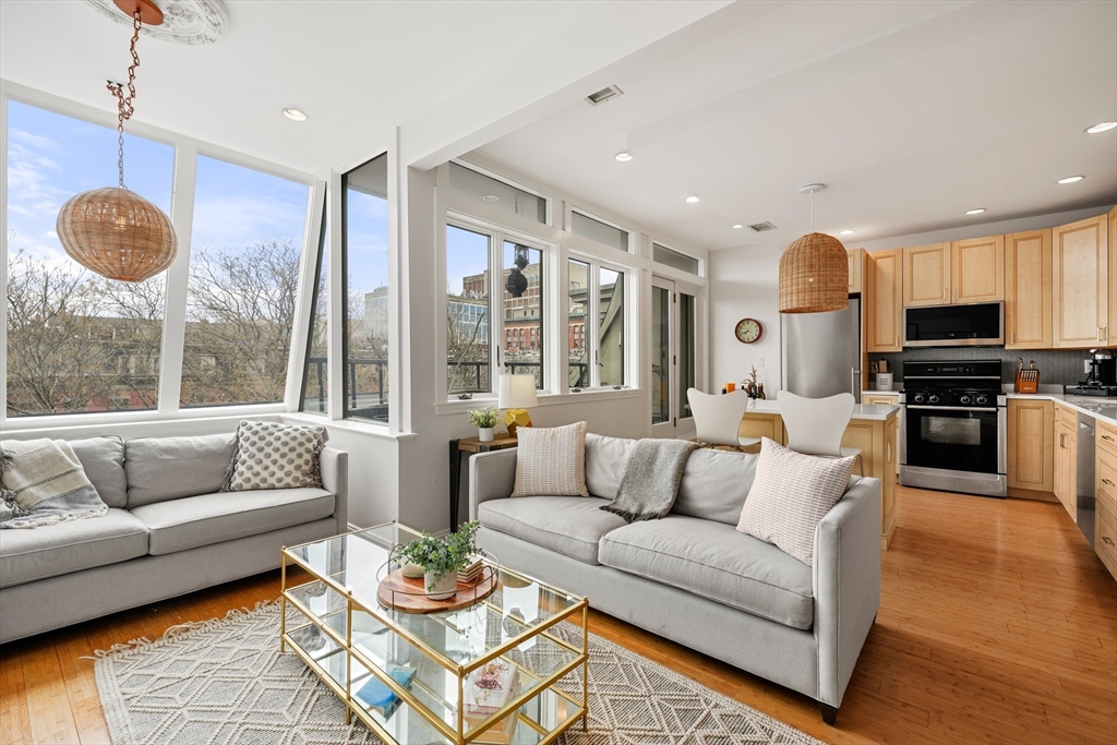 a living room with furniture a flat screen tv and a large window