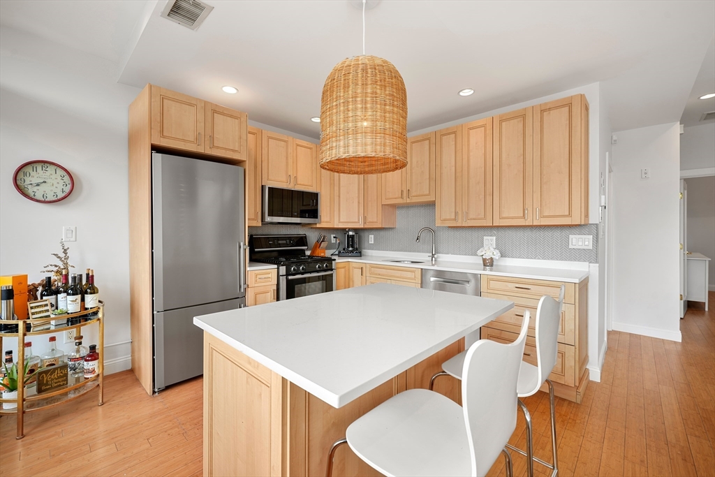21 Worcester Square, Unit 5 Boston, MA 02118 - Photo 6 of 33 a kitchen with a refrigerator a stove cabinets and wooden floor