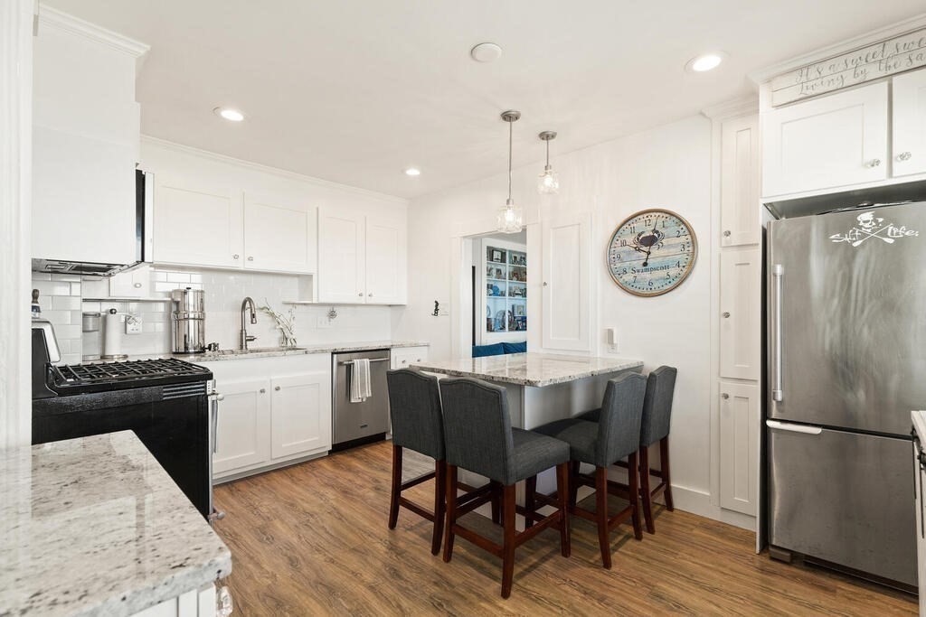 75 Puritan Road, Unit 1 Swampscott, MA 01907 - Photo 5 of 17 a kitchen with a table chairs and a refrigerator