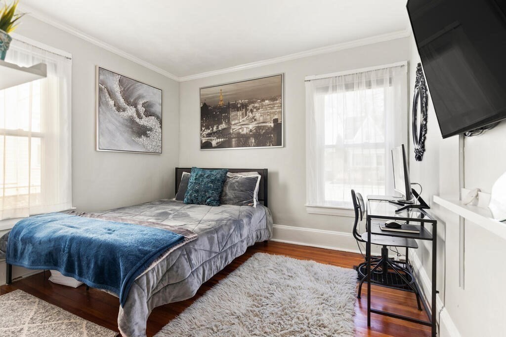 75 Puritan Road, Unit 1 Swampscott, MA 01907 - Photo 9 of 17 a bedroom with a bed wooden floor and a flat screen tv