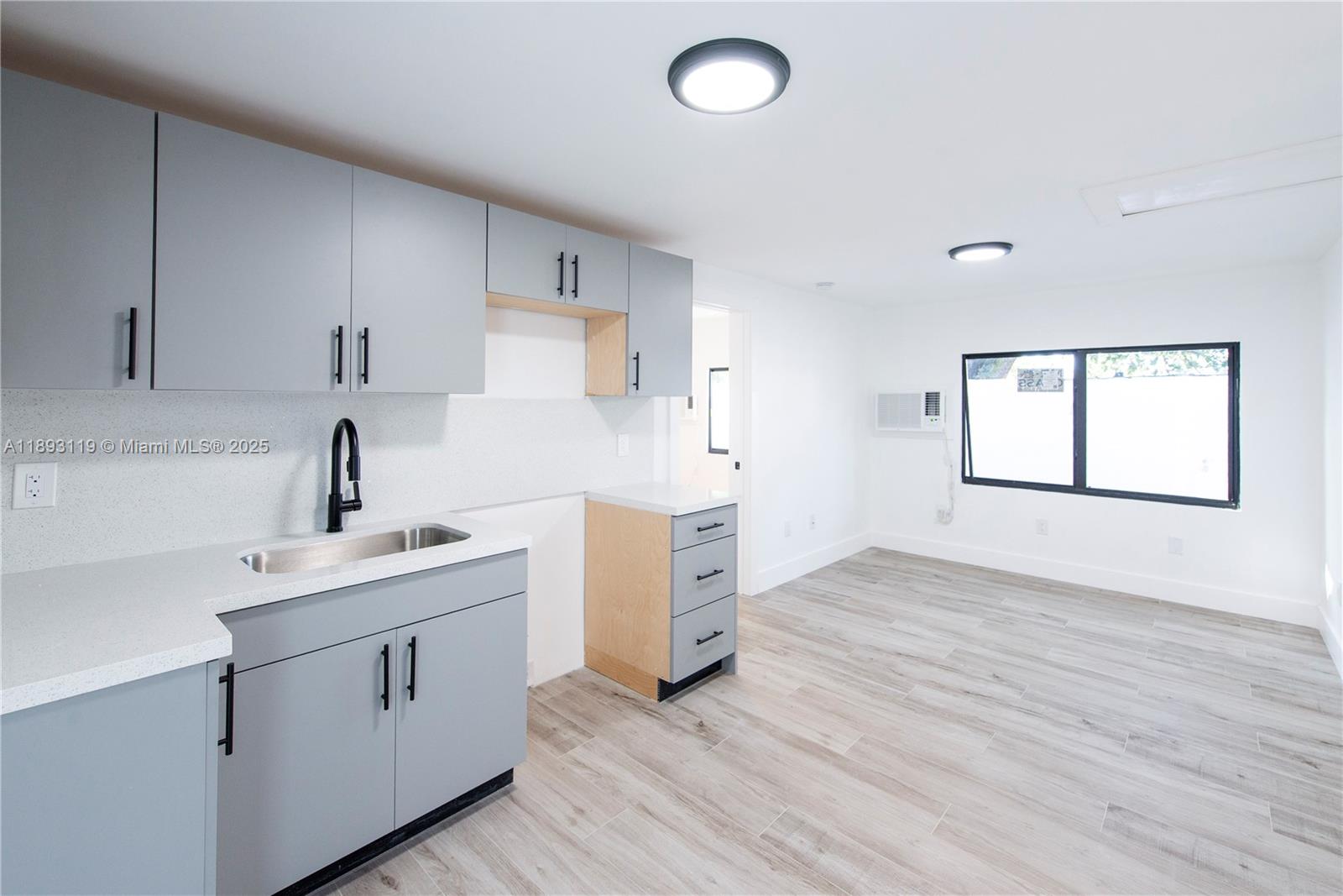 764 Northwest 36th Avenue, Unit 2 Miami, FL 33125 - Photo 3 of 11 a kitchen with a sink cabinets stainless steel appliances and a window