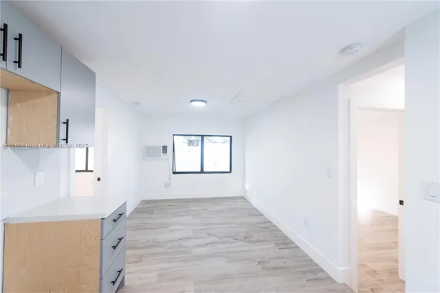a view of a kitchen with wooden floor and a window