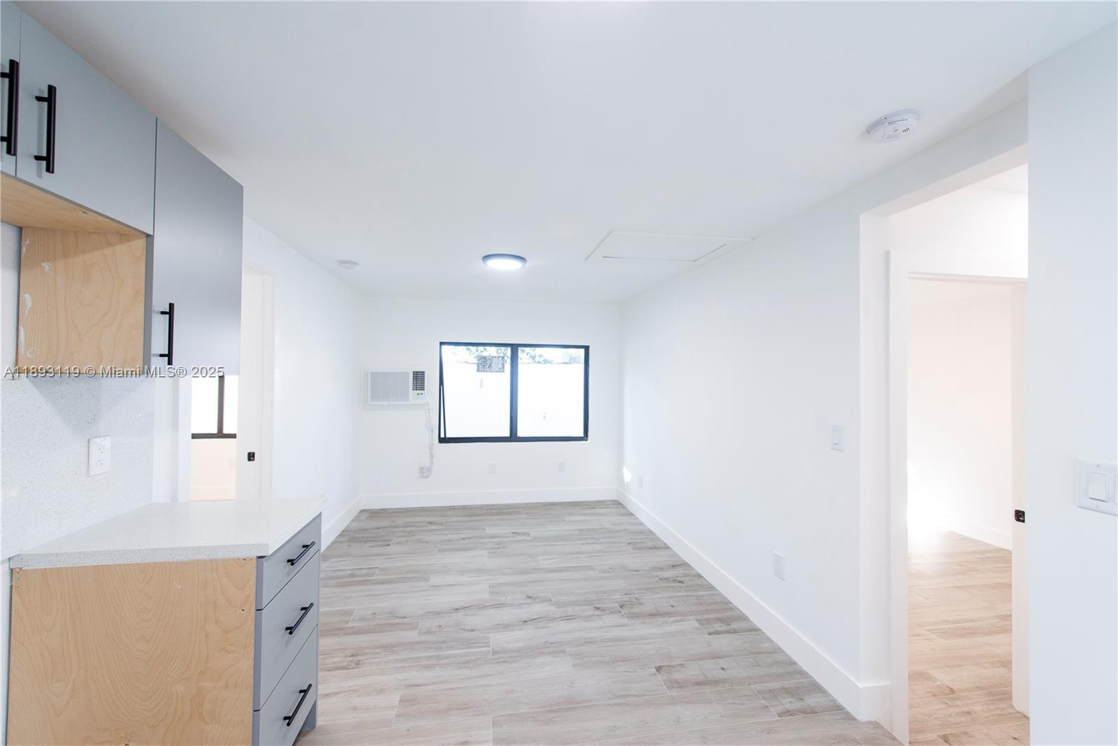 764 Northwest 36th Avenue, Unit 2 Miami, FL 33125 - Photo 4 of 11 a view of a kitchen with wooden floor and a window