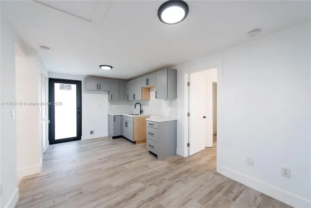 a view of a kitchen with wooden floor and electronic appliances