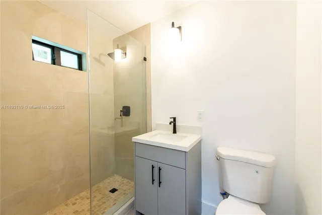 a bathroom with a toilet a sink a mirror and shower