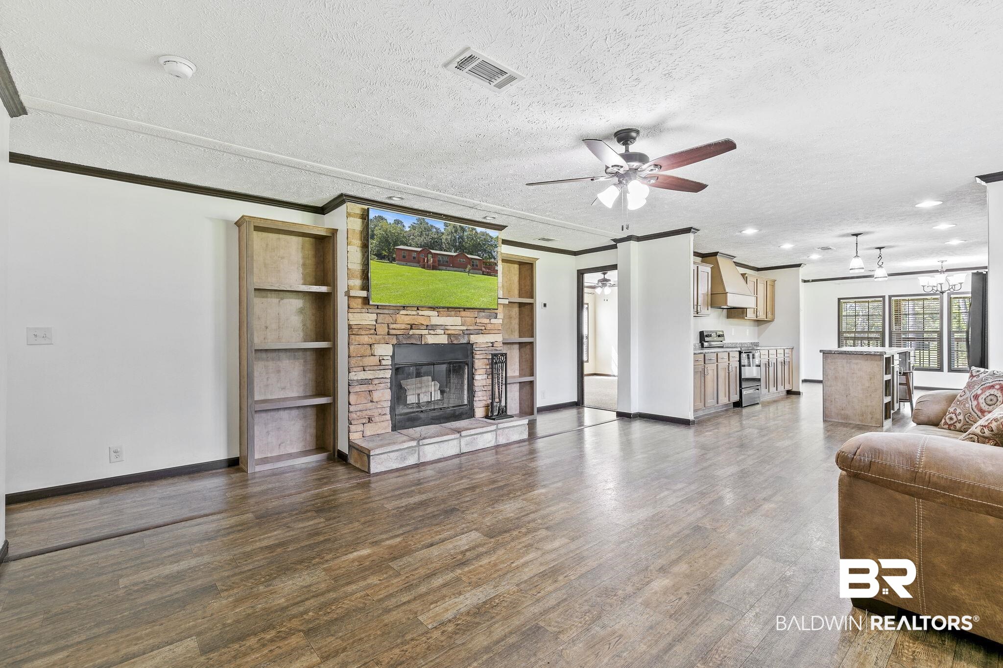 35641 County Road 39 Stapleton, AL 36578 - Photo 10 of 46 Living room featuring a textured ceiling, a stone fireplace, dark wood-type flooring, and ceiling fan