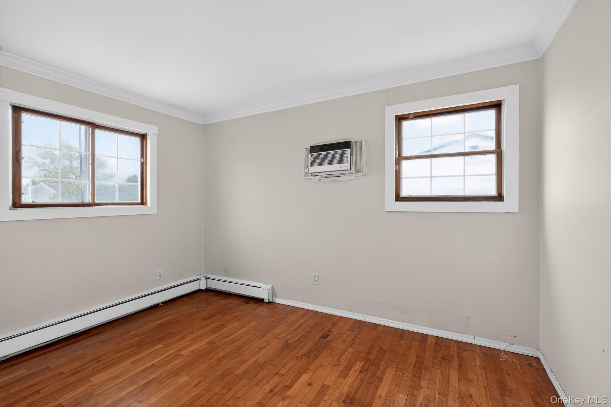 138 Spring Street Massapequa, NY 11758 - Photo 18 of 45 a view of an empty room with wooden floor and a window