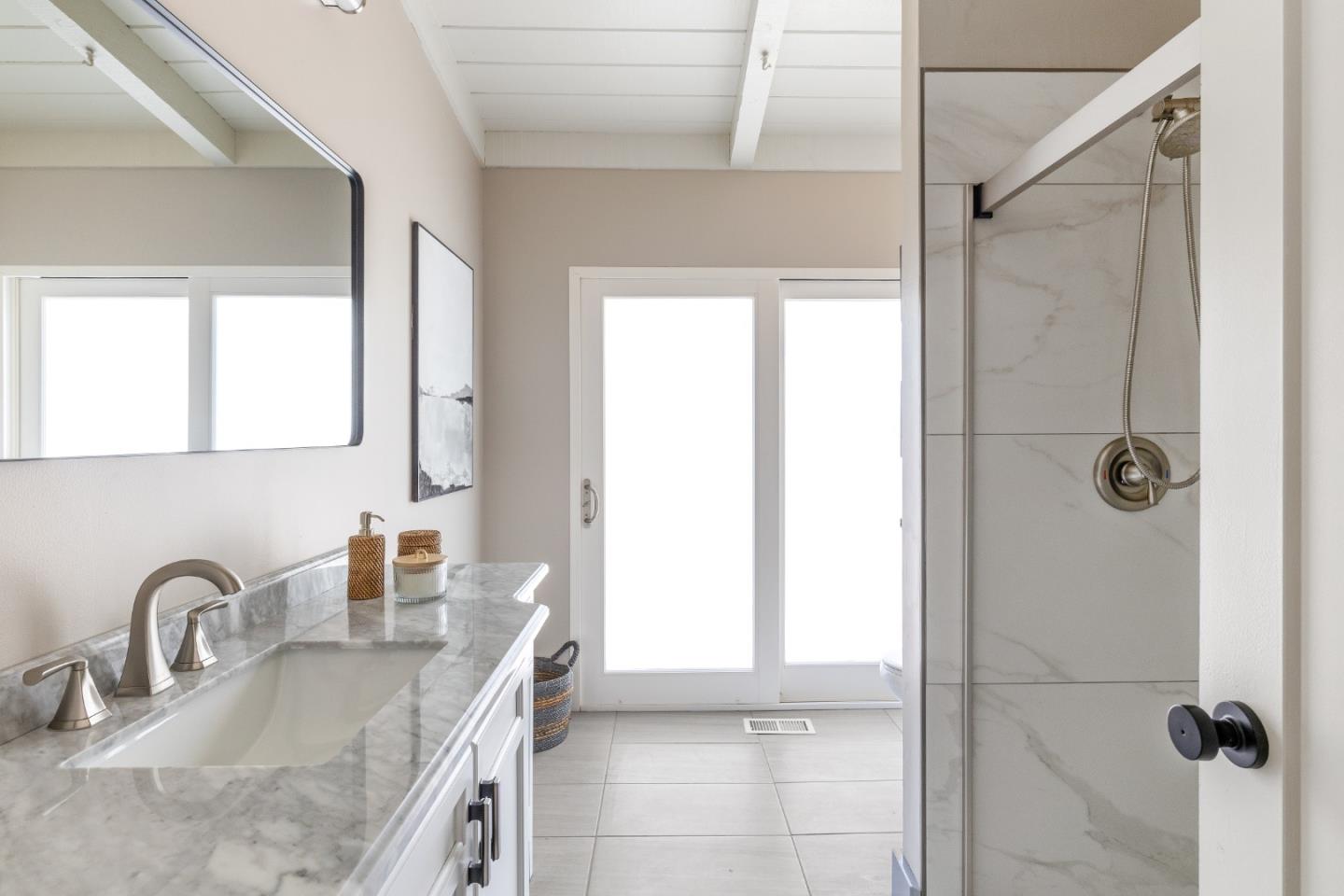 25165 Stewart Place Carmel, CA 93923 - Photo 26 of 51 a bathroom with a granite countertop sink a mirror and a shower