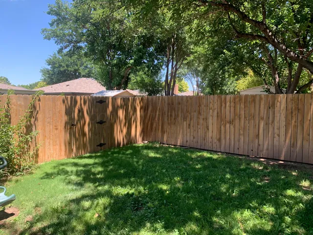 a view of a backyard with wooden fence