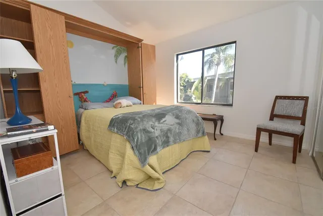 a bedroom with a bed a chair and a window