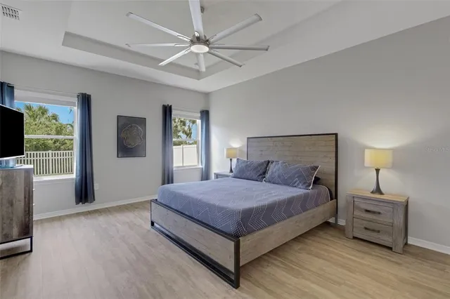 a bedroom with a large bed a flat tv screen and dresser