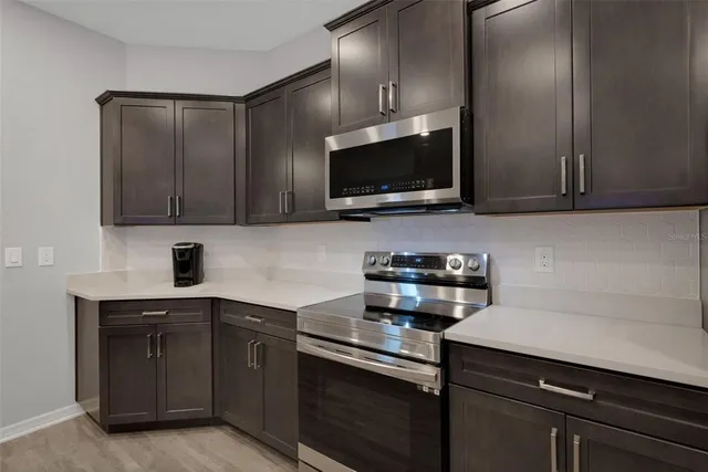 a kitchen with stainless steel appliances granite countertop wooden cabinets a stove top oven a sink and dishwasher