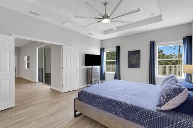 a bedroom with a large bed a flat tv screen and dresser