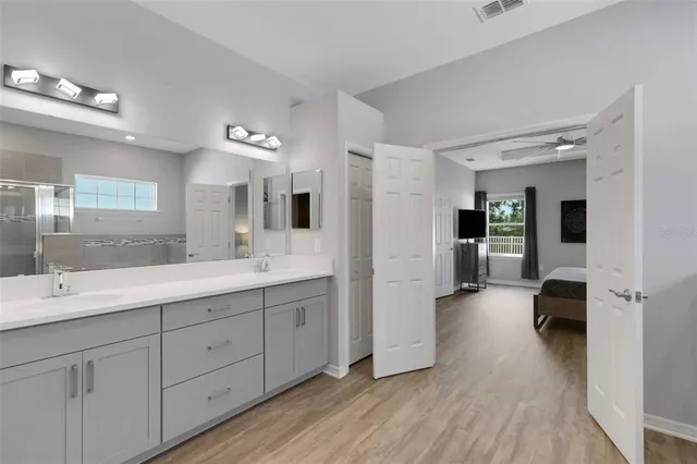 a spacious en suite bathroom with a double vanity sink and mirror