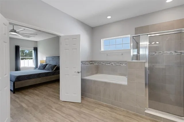a spacious bathroom with a tub shower and a sink