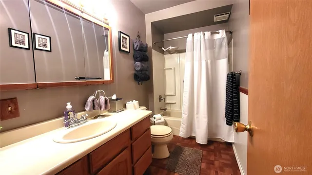 a bathroom with a granite countertop sink toilet and shower