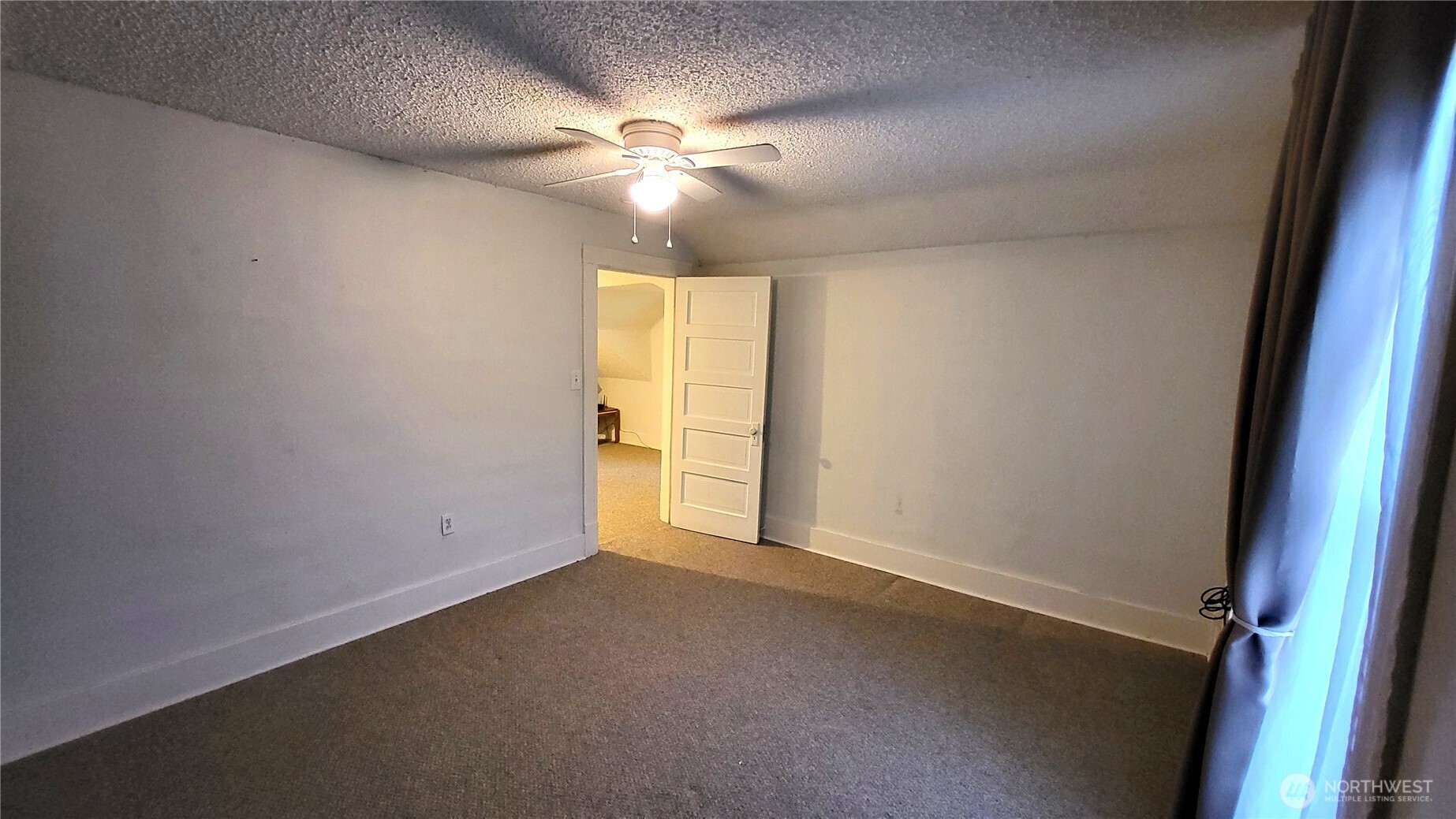 1113 South County Road Warden, WA 98857 - Photo 24 of 40 an empty room with a chandelier fan and windows