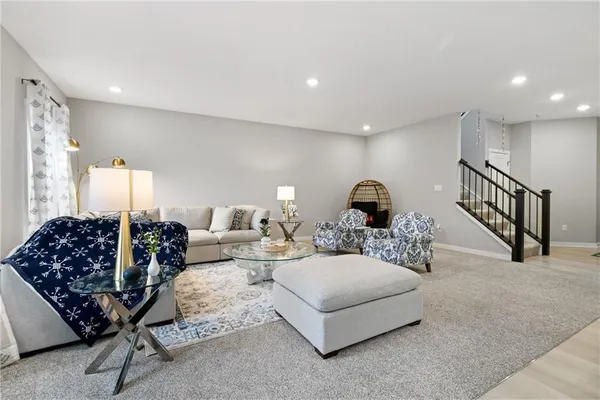 a living room with furniture wooden floor and a large window