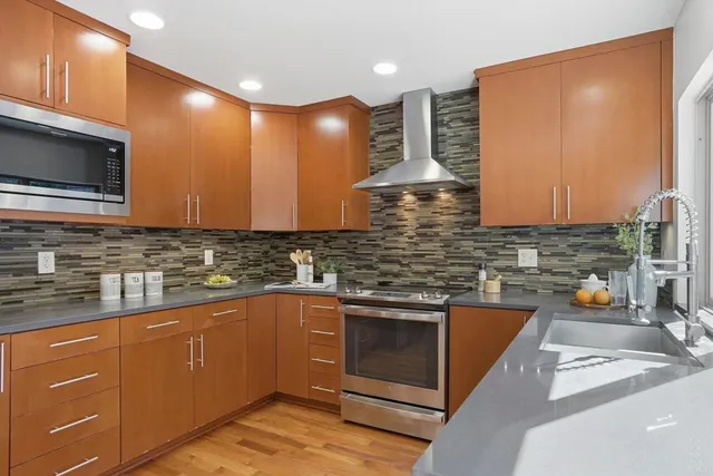 a kitchen with stainless steel appliances granite countertop a sink and a stove