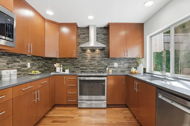 a kitchen with stainless steel appliances granite countertop a sink a stove and cabinets