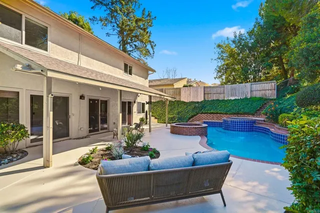 a view of a patio with couches table and chairs potted plants and large tree