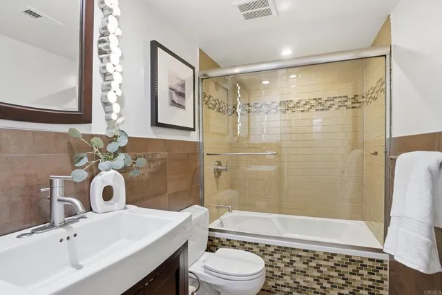 a bathroom with a sink toilet a mirror and shower