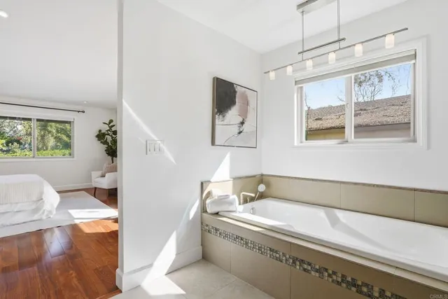 a spacious bathroom with a tub double vanity and a window