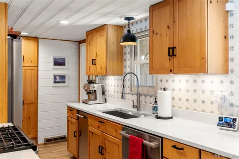 a kitchen with sink a stove and cabinets