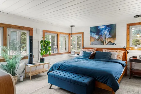 a spacious bedroom with a large bed couch and a large window