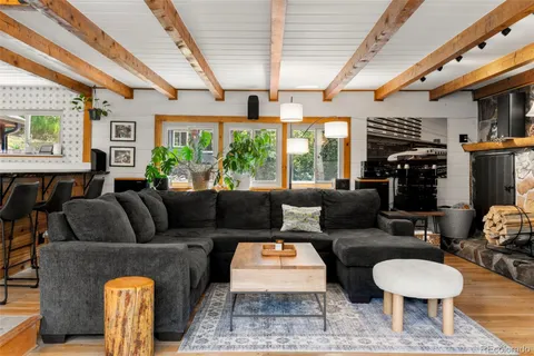 a living room with furniture a fireplace and a large window