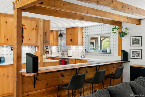 a kitchen with a sink and chairs