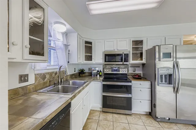a kitchen with stainless steel appliances granite countertop a sink stove microwave and refrigerator
