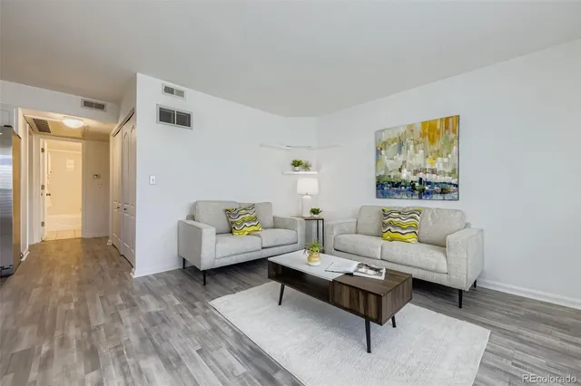 a living room with furniture and a wooden floor