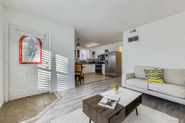 a living room with furniture and kitchen view