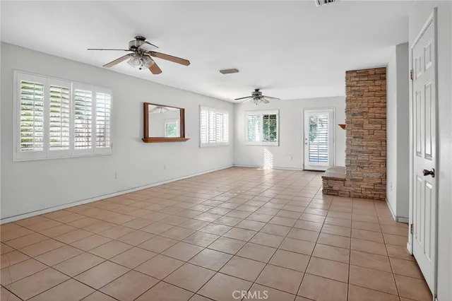 an empty room with a window and a ceiling fan