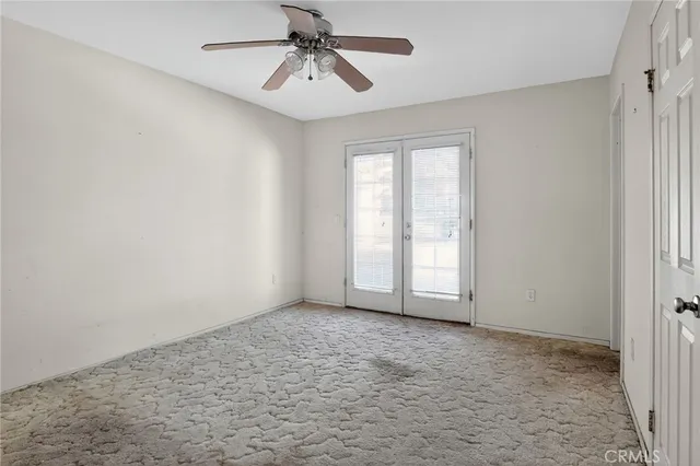 a view of an empty room with fireplace and window