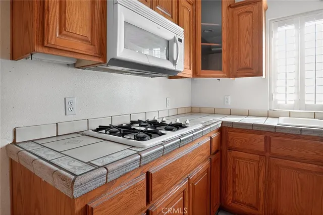 an empty room with a hallway and a chandelier fan