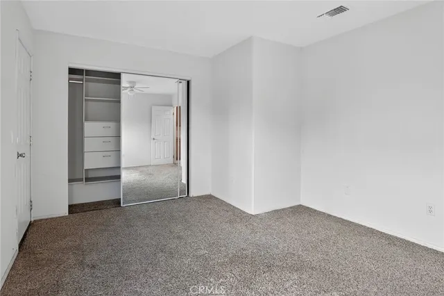 an empty room with windows and closet