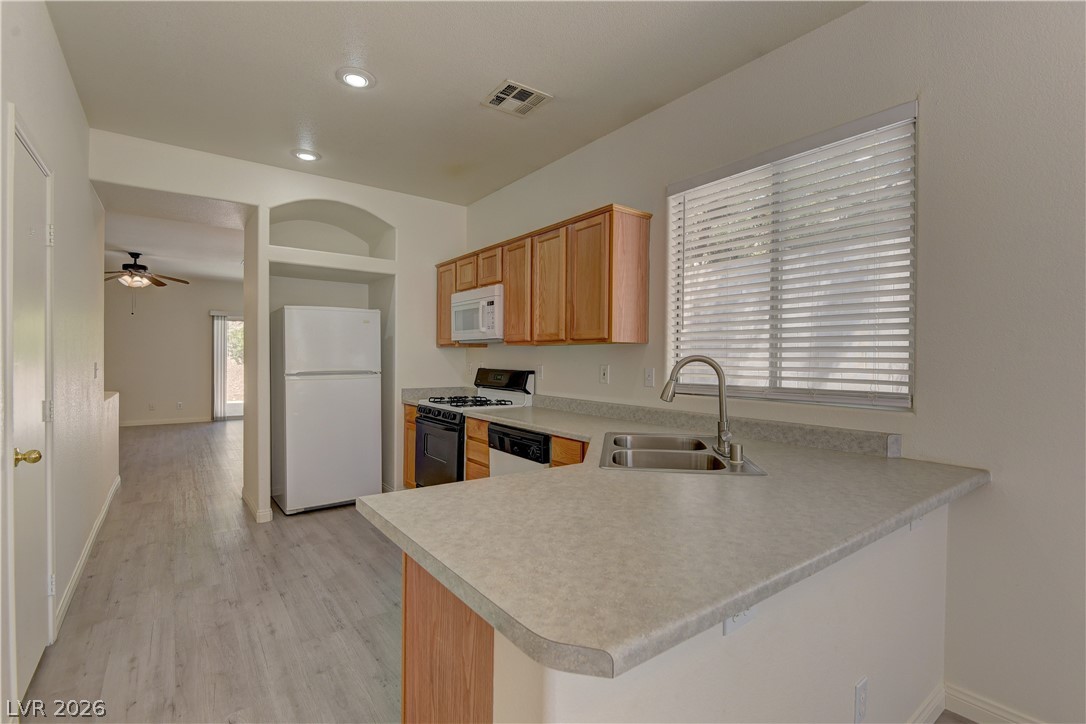 4613 Rising Cove Street Las Vegas, NV 89129 - Photo 7 of 20 Bright and functional kitchen featuring a dual-basin sink and a clean, inviting aesthetic.