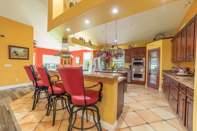 a kitchen with stainless steel appliances kitchen island granite countertop a sink and cabinets