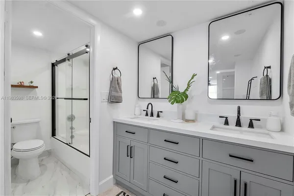 a bathroom with a double vanity sink toilet and shower